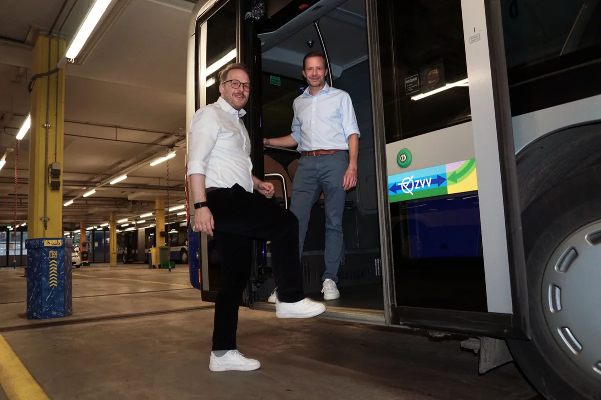 Man sieht zwei Männer, die in einen Bus einsteigen.